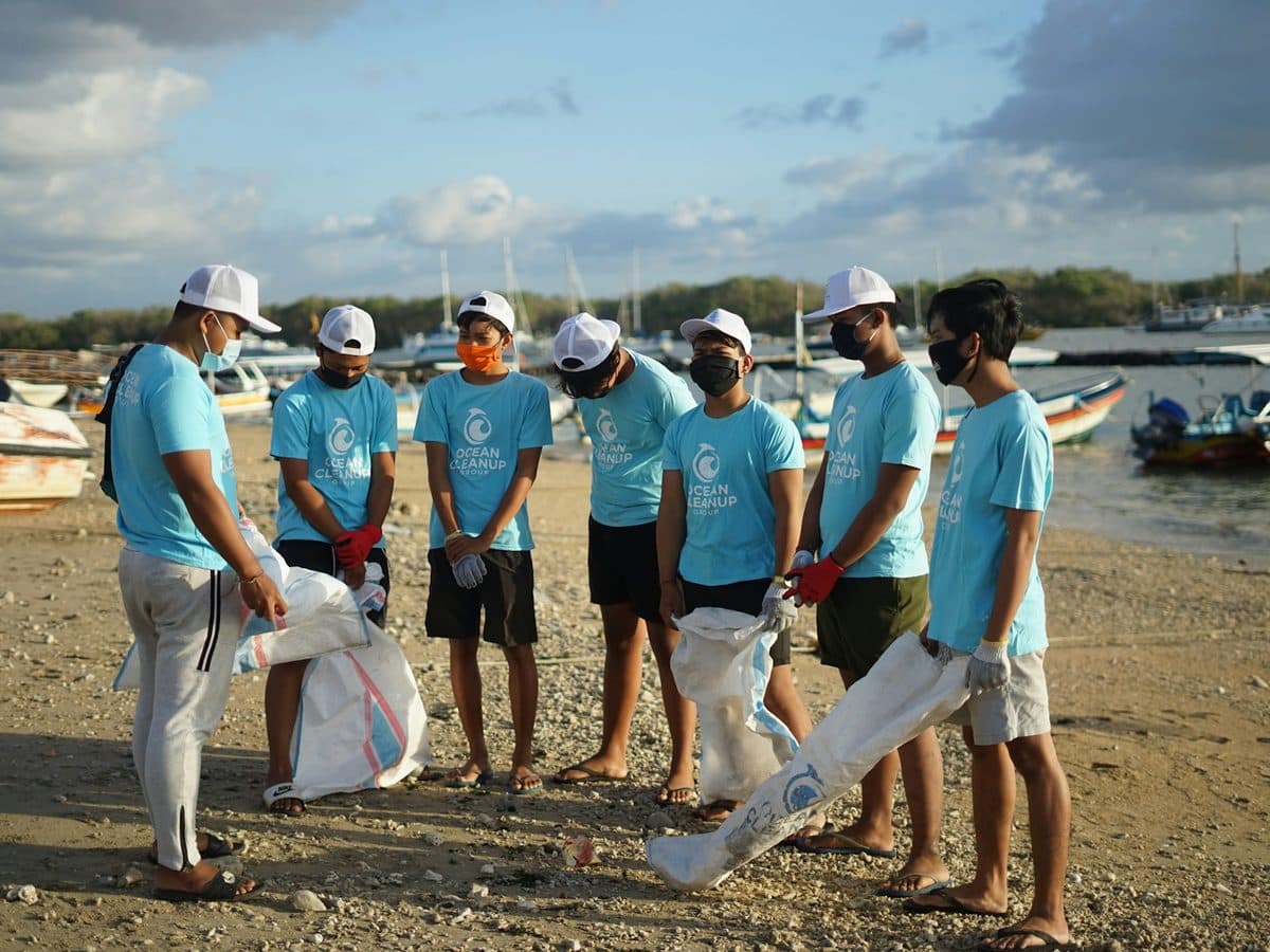 Une équipe de salariés en t-shirts assortis ramasse des déchets sur une plage