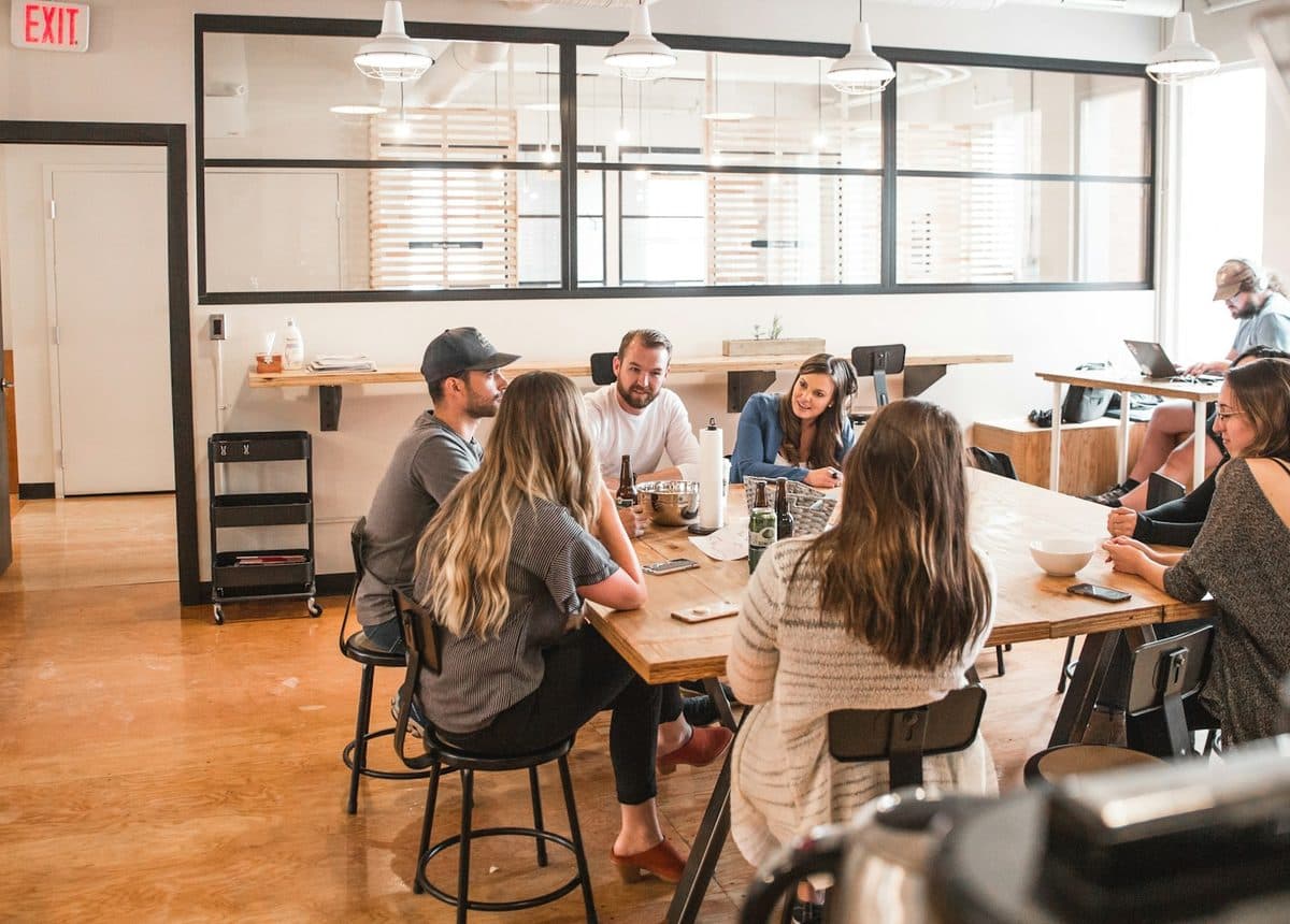 Une équipe travaille autour d'une grande table dans un bureau ouvert